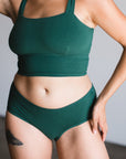 Mid rise brief in lagoon on model, front view. Lagoon is a dark green teal color.