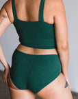 back view of model wearing mid rise brief in lagoon dark green teal.