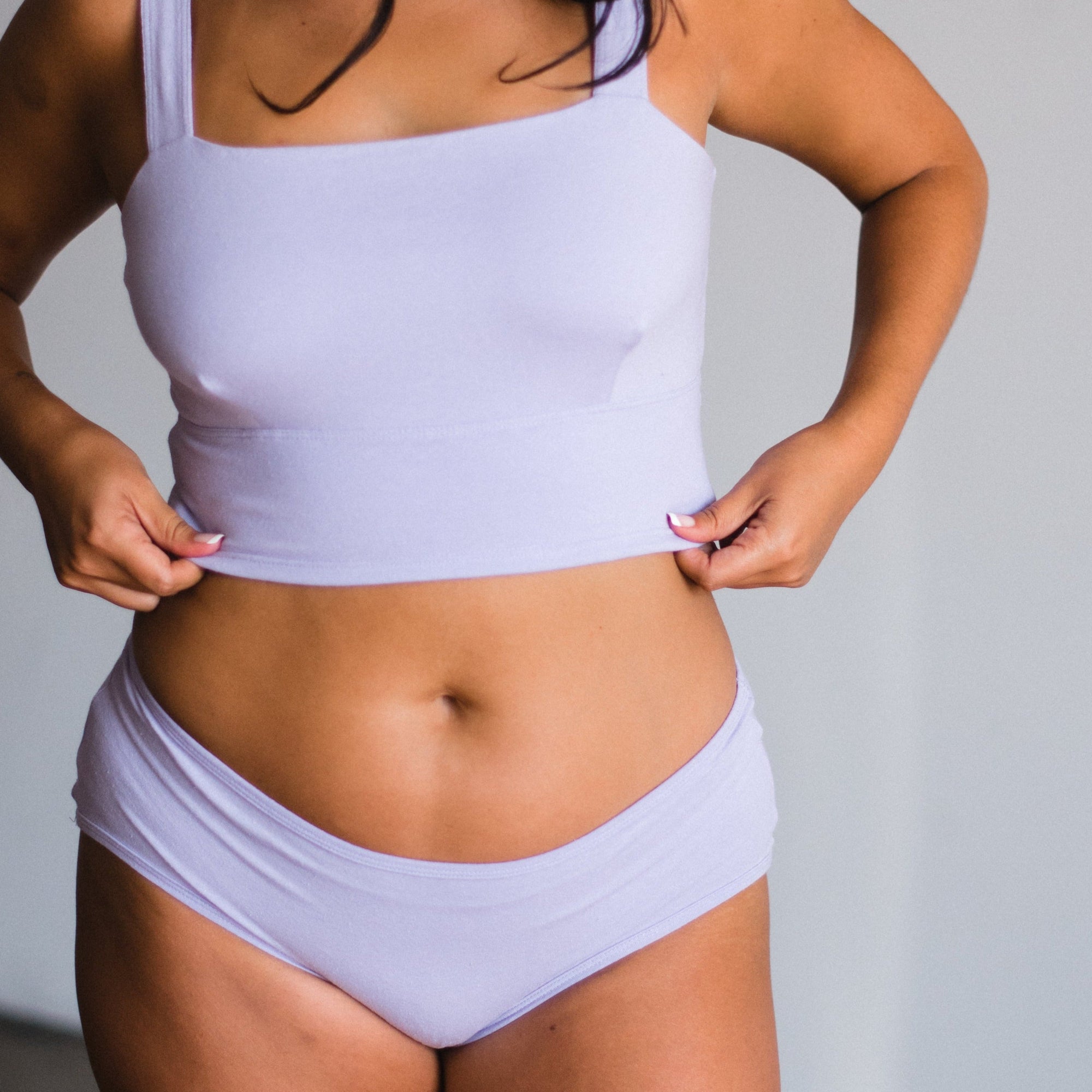 model wearing mid rise briefs in lilac a light purple color. Made from organic cotton and hemp